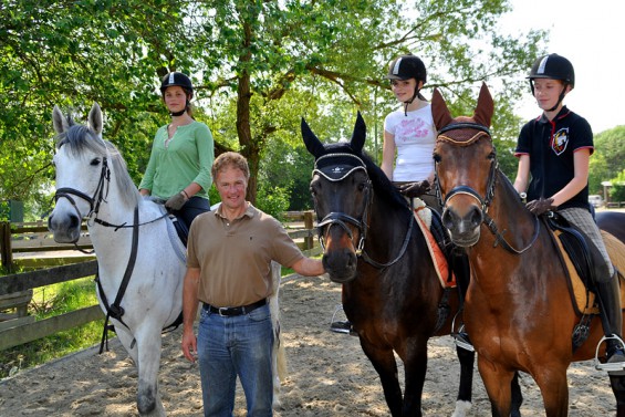 Reitlehrer Stefan Weyandt mit drei Schulreitern auf der Reitanlage des Reitstalls